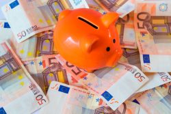 Pink piggy bank on money, euros bills.