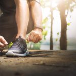 Sport and running idea concept. Young man runner tying shoelaces.