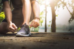 Sport and running idea concept. Young man runner tying shoelaces.