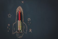 Top view Back to school or business start up background.The rocket create by pencil and drawing by chalk board with around star  on blackboard.copy space.above view.flat lay.