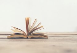 Vintage old books on wooden deck table background.