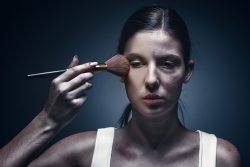 Close up portrait of a crying woman with bruised skin and black eyes at studio. The concept of protection from violence